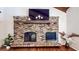 Living room fireplace featuring rustic brick surround, wooden mantle, mounted television, and decorative accents at 2151 Desmond Dr, Decatur, GA 30033
