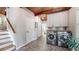 Well-lit laundry room featuring a wood-beamed ceiling, tile floors, and modern washer and dryer at 2151 Desmond Dr, Decatur, GA 30033