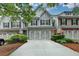 Charming townhouse with a brick-and-siding exterior, two-car garage and manicured landscaping at 2895 Cross Creek Dr, Cumming, GA 30040