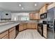 Bright kitchen showcasing wooden cabinets, modern black appliances, and a view into the next room, perfect for entertaining at 2895 Cross Creek Dr, Cumming, GA 30040