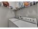 Laundry room includes a white washer and dryer, and shelving above for storage at 2895 Cross Creek Dr, Cumming, GA 30040