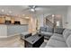 Bright and open living room leading to the kitchen with a gray sectional sofa and ottoman at 2895 Cross Creek Dr, Cumming, GA 30040