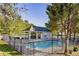 Community pool with fenced perimeter, covered lounging area, and surrounding trees at 323 Dewpoint Ct # 35, Marietta, GA 30064