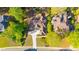 Aerial view showcasing a well-manicured home with mature trees, green lawns, and a concrete driveway at 5685 Commons Ln, Alpharetta, GA 30005