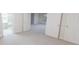 Spacious room with neutral walls and carpet, offering a walk-in closet and an open doorway into another area at 5685 Commons Ln, Alpharetta, GA 30005