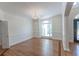 Formal dining room featuring hardwood floors, large windows, crown molding, and modern chandelier at 5685 Commons Ln, Alpharetta, GA 30005