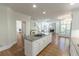 Kitchen with island, hardwood floors, and view of a living room with a fireplace at 5685 Commons Ln, Alpharetta, GA 30005