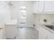 Well-lit laundry room with ample cabinet space, countertops, sink, and a view to the outside at 5685 Commons Ln, Alpharetta, GA 30005
