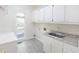 Bright laundry room featuring modern cabinets, sink, countertop and window views at 5685 Commons Ln, Alpharetta, GA 30005