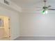 Bright room with neutral walls and carpet, featuring a ceiling fan and an arched doorway leading to an adjoining room at 5685 Commons Ln, Alpharetta, GA 30005