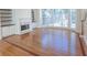 Living area with hardwood floors, fireplace, and bright bay windows overlooking the backyard at 5685 Commons Ln, Alpharetta, GA 30005