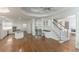 Spacious living area with hardwood floors connects to kitchen with bar and a staircase at 5685 Commons Ln, Alpharetta, GA 30005