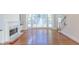 Living area with hardwood floors, fireplace, and bright bay windows overlooking the backyard at 5685 Commons Ln, Alpharetta, GA 30005