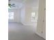 Light-filled room with neutral walls and carpet, featuring a ceiling fan and an open layout with additional rooms beyond at 5685 Commons Ln, Alpharetta, GA 30005