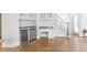 Open living room featuring a bar area with beverage coolers, and staircase leading to the upper level at 5685 Commons Ln, Alpharetta, GA 30005