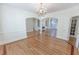 Open living room showcases hardwood floors, chandelier, and entryways to other rooms at 5685 Commons Ln, Alpharetta, GA 30005