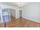 Open living area with hardwood floors, chandelier, archway, and ample natural light at 5685 Commons Ln, Alpharetta, GA 30005