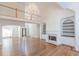 Bright living room with fireplace, chandelier, hardwood floors, and built-in bookshelves at 5685 Commons Ln, Alpharetta, GA 30005