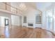 Open living area with hardwood floors, fireplace, and a crystal chandelier hanging from vaulted ceiling at 5685 Commons Ln, Alpharetta, GA 30005