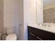 Bathroom featuring a toilet, dark cabinet, sink with white countertops and gray tiled wall at 7850 Willoughby Ct, Alpharetta, GA 30005