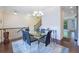 Elegant dining area with modern chandelier, glass table, and staircase at 7850 Willoughby Ct, Alpharetta, GA 30005