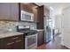 Modern kitchen with stainless steel appliances, granite countertops, and dark wood cabinetry at 7850 Willoughby Ct, Alpharetta, GA 30005