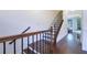 Elegant staircase with hardwood steps and wrought iron railing, bathed in natural light at 7850 Willoughby Ct, Alpharetta, GA 30005