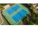 Aerial view of community tennis courts featuring blue playing surfaces and professional lighting for evening play at 7850 Willoughby Ct, Alpharetta, GA 30005