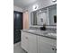 Updated bathroom features a dual vanity with granite countertops, framed mirror, and modern black door at 101 Stroud Se Dr, Mableton, GA 30126