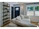 Cozy living room with a plush white sofa, rustic shelving, and a sunlit window with white curtains at 101 Stroud Se Dr, Mableton, GA 30126
