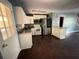 Another view of the kitchen showcasing stainless steel appliances, white cabinetry, and dark wood floors at 142 Davis Mill Ct, Lawrenceville, GA 30044