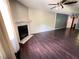 Spacious living room featuring dark wood floors, a fireplace, a ceiling fan and neutral wall paint at 142 Davis Mill Ct, Lawrenceville, GA 30044