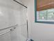 Bathroom featuring a glass-enclosed shower with safety bars and a window with wood blinds at 1517 Colony East Cir, Stone Mountain, GA 30083