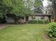 Charming single-story brick home with a well-manicured lawn and mature trees shading the front at 1517 Colony East Cir, Stone Mountain, GA 30083