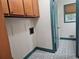 Laundry room with blue patterned tile floors, overhead cabinets, and washer/dryer hookups at 1517 Colony East Cir, Stone Mountain, GA 30083