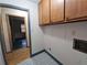 Laundry area with blue patterned tile, upper cabinets, and connections for washer and dryer at 1517 Colony East Cir, Stone Mountain, GA 30083
