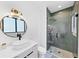 Modern bathroom with sleek fixtures, stand up shower, and unique round mirror at 2577 Kilgore Rd, Buford, GA 30519