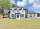 Stunning two-story home with a modern design, complemented by a lush green lawn and mature trees at 2577 Kilgore Rd, Buford, GA 30519
