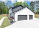 Side view of a pristine white home featuring an attached two-car garage and well-manicured landscaping at 2577 Kilgore Rd, Buford, GA 30519