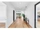 Long hallway featuring light wood floors, white walls, and views into the living room at 2577 Kilgore Rd, Buford, GA 30519