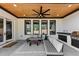 Covered patio with an outdoor kitchen, ceiling fan, and comfortable seating area at 2577 Kilgore Rd, Buford, GA 30519