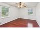 This bedroom features gleaming hardwood floors, dual windows, and a ceiling fan with a light fixture at 3240 Corktree Trl, Stonecrest, GA 30038