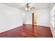 This bedroom features gleaming hardwood floors, white walls, two windows, and a ceiling fan with a light fixture at 3240 Corktree Trl, Stonecrest, GA 30038
