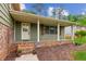 Inviting front porch of home featuring brick accents and a cozy sitting area at 3240 Corktree Trl, Stonecrest, GA 30038