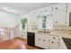 Bright kitchen with white cabinets, speckled countertops, stainless steel sink and black dishwasher at 3240 Corktree Trl, Stonecrest, GA 30038