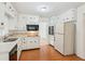 Well-lit kitchen featuring white cabinets, wood floor and an electric cooktop at 3240 Corktree Trl, Stonecrest, GA 30038