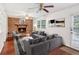 Cozy living room with brick fireplace, wood floors, and comfortable gray sofas at 3240 Corktree Trl, Stonecrest, GA 30038