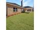 Spacious green lawn extends from a brick home with covered patio for outdoor living at 5301 Tuscany Dr, Douglasville, GA 30135