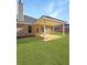 Brick home featuring a covered patio perfect for outdoor entertaining in a grassy backyard at 5301 Tuscany Dr, Douglasville, GA 30135