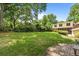 Lush backyard featuring a spacious lawn, a screened porch, and a brick patio with a fire pit at 1590 Johnson Ne Rd, Atlanta, GA 30306